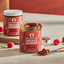 Load image into Gallery viewer, Two chocolate raspberry honey cream spread with one of the jars opened.