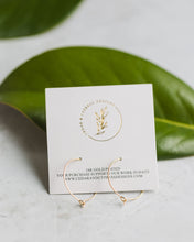Load image into Gallery viewer, Dainty Gold Hoop packaging on top of green leaf.