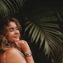 Load image into Gallery viewer, Girl smiling and wearing the small Brave K&#39;lani hair tie and bracelet around her wrist.
