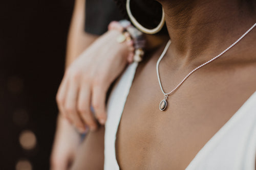 Lady wearing Angie Necklace in Silver Horn and black. 